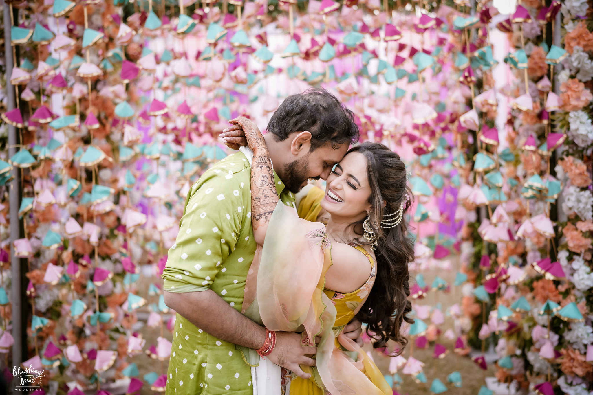 Couple embracing in front of a floral backdrop