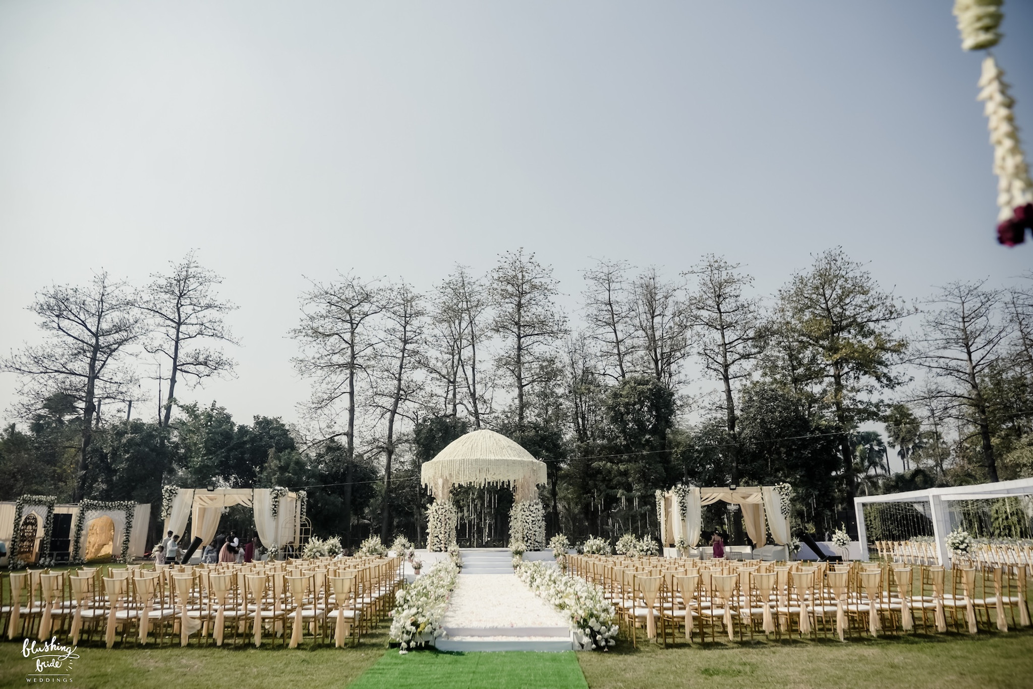 Ceremony seating laid out on a lawn in daylight