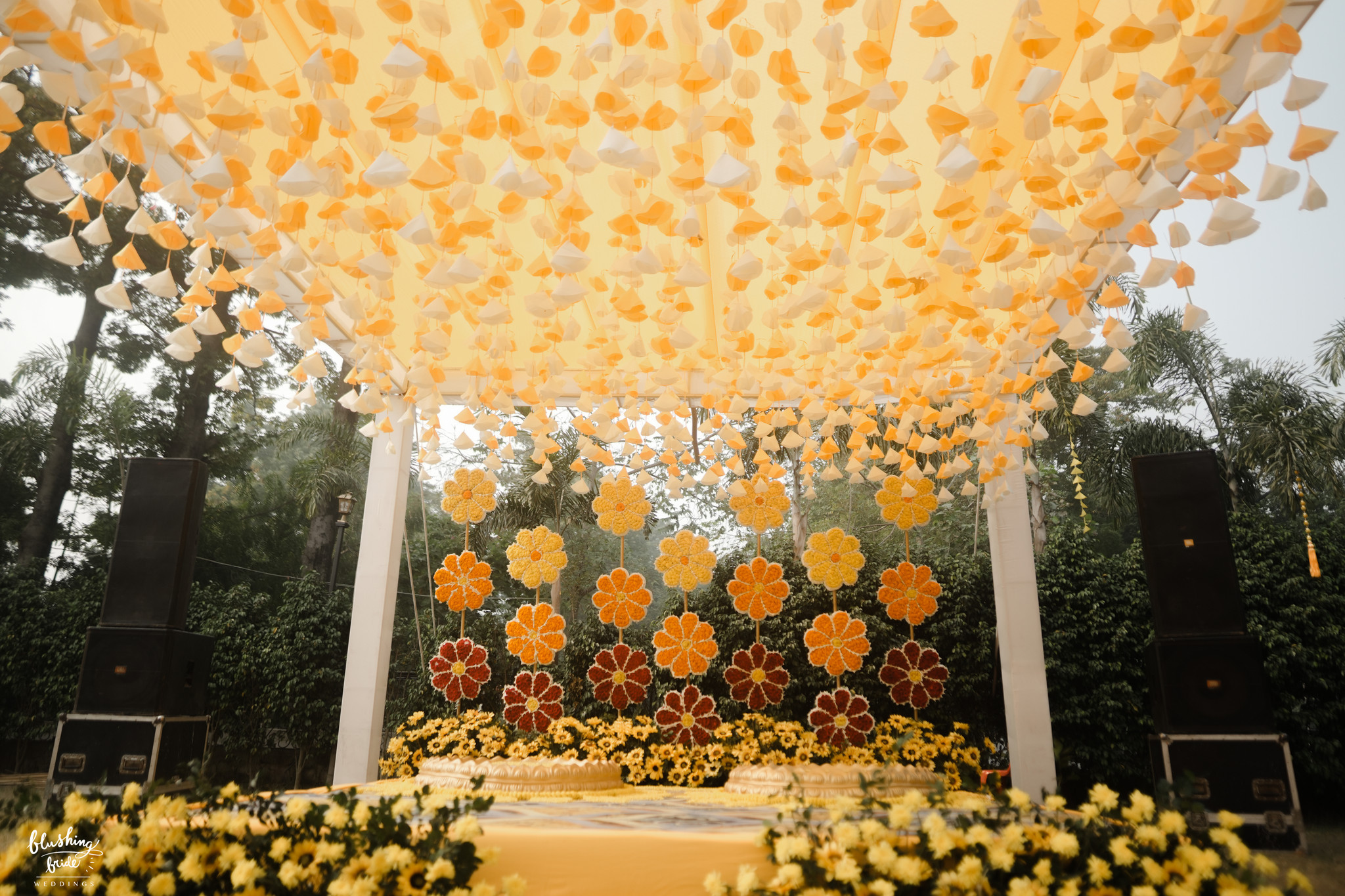 Marigold canopy suspended above an outdoor mandap